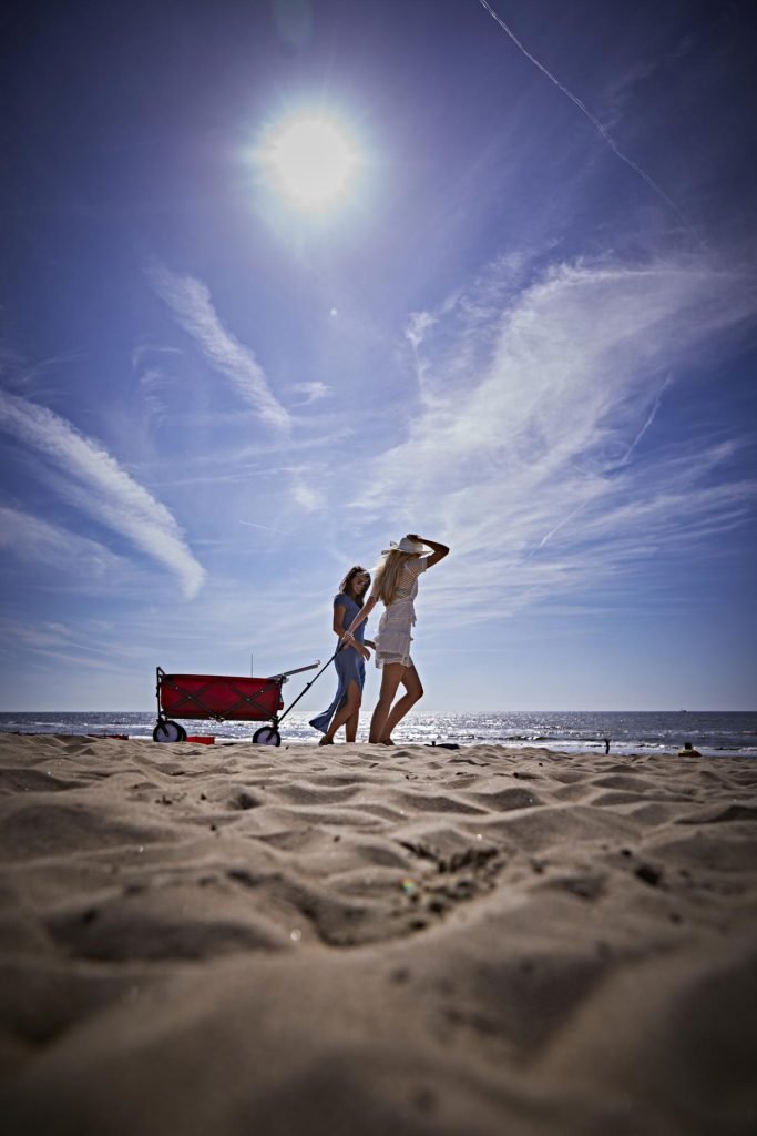 two woman at a beach walking over the sand