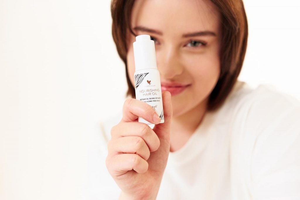 woman portrait smiling with an oil in her hand