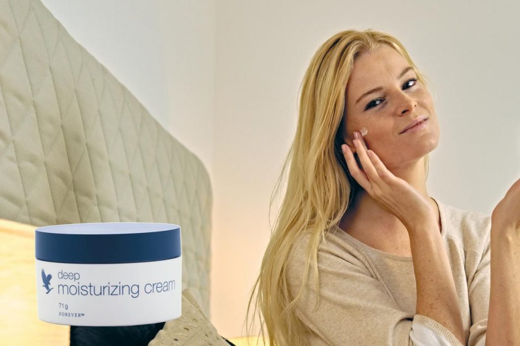 blond woman with a cream putting on her face